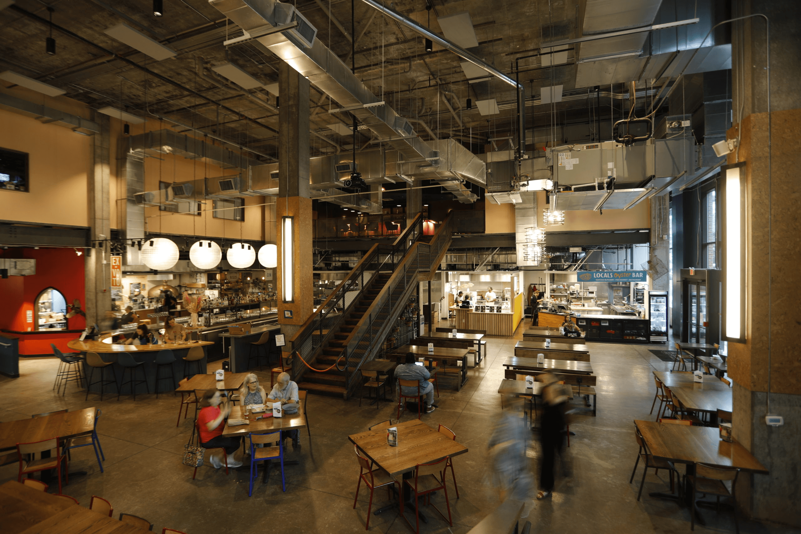 a group of people sitting at tables in a restaurant