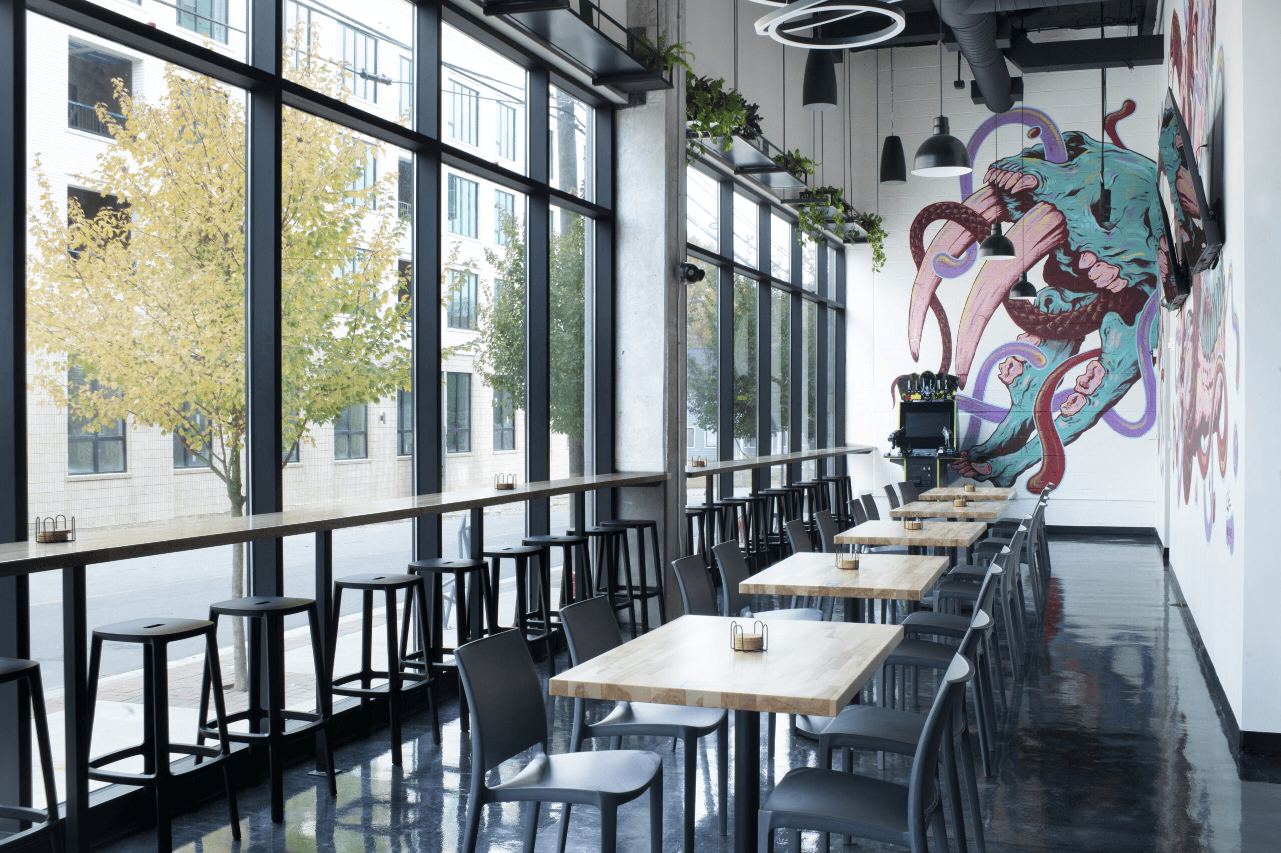 a restaurant with tables and chairs and a mural on the wall