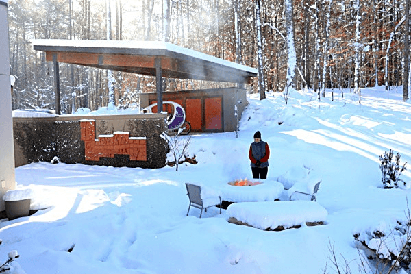 a person standing in the snow in front of a building