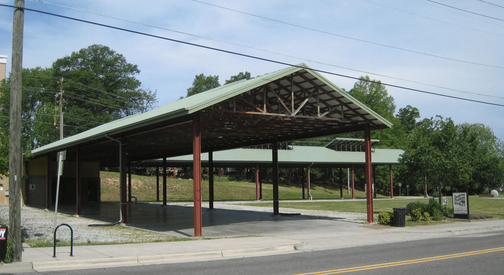 a covered parking lot on the side of a road