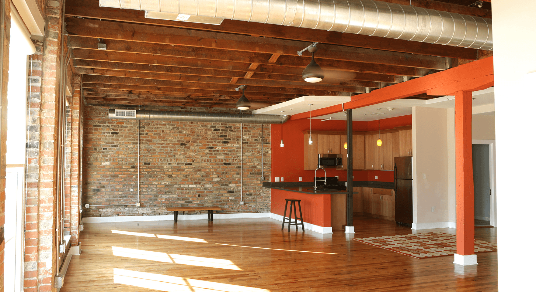 a room with a brick wall and wooden floors